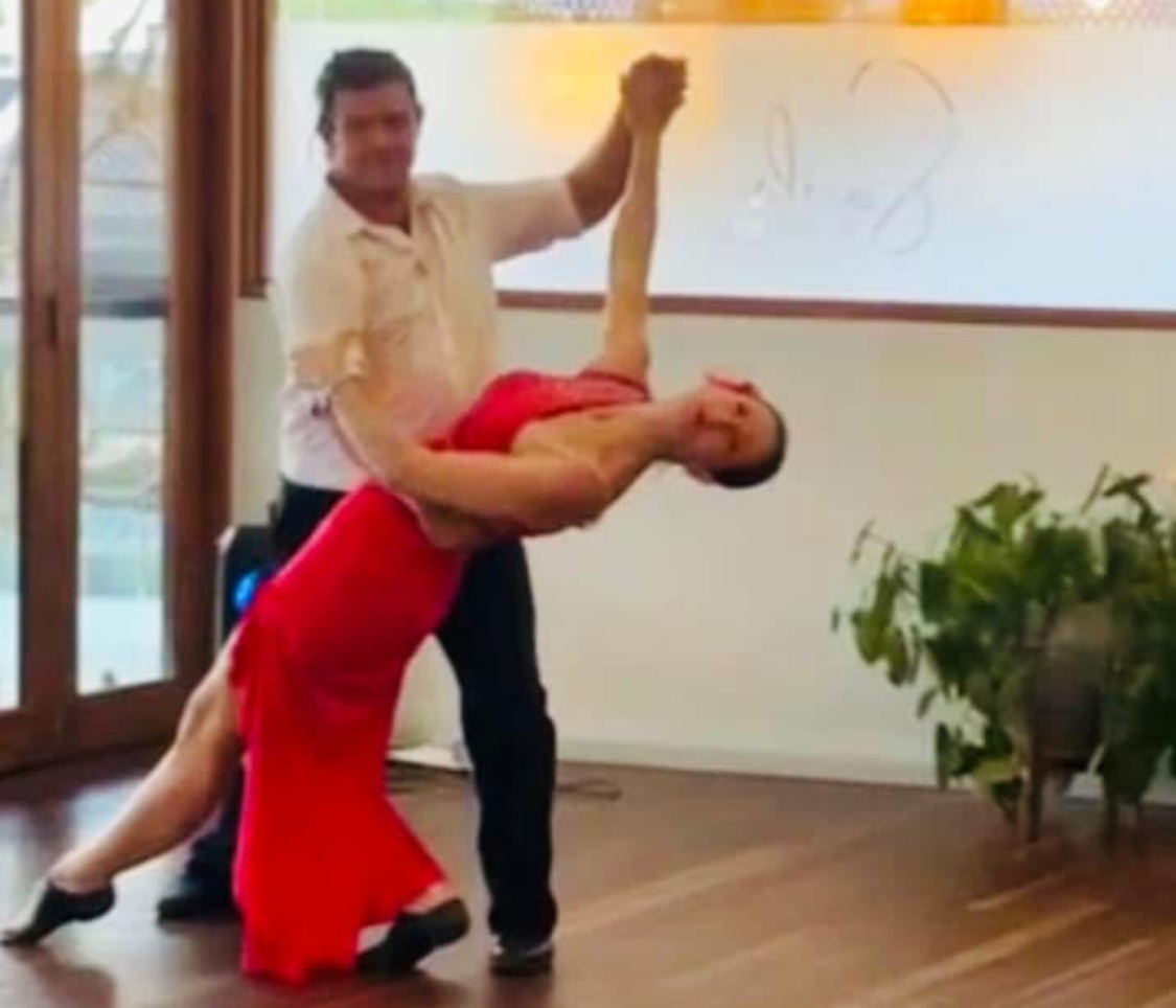 Ballroom dance couple performing elegant dip at dance4Life FNQ